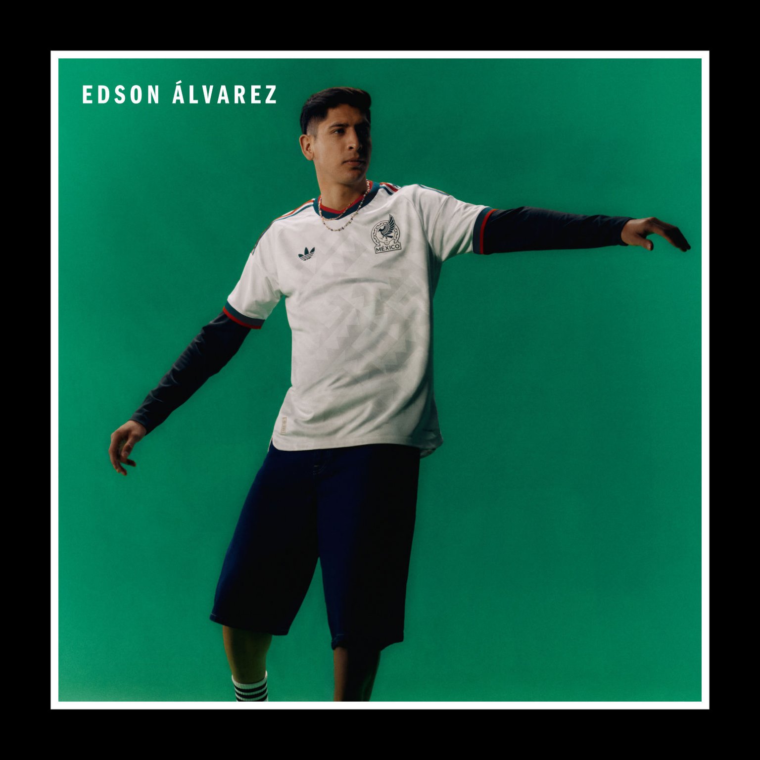 The image shows a young man wearing a white sports jersey with the name "Edson Alvarez" printed on it, standing in front of a solid green background.